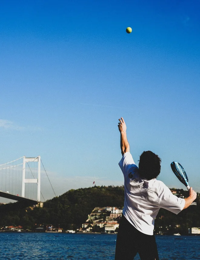 Servis vuruşu yapan padel oyuncusu