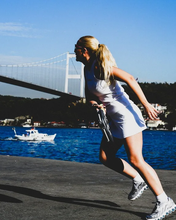 Mavi padel kortunda raketiyle vuruşa hazırlanan oyuncu